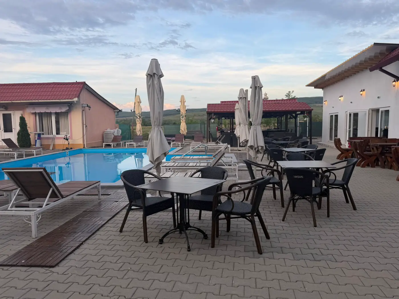 Terasa de la Batiz, cu mese în jurul piscinei restaurantului și priveliște spre dealuri